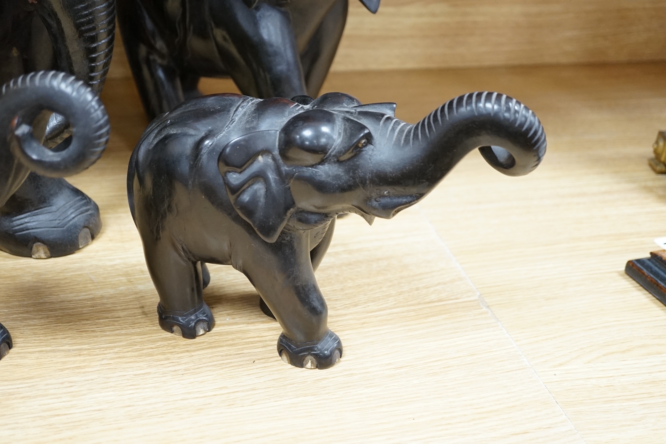 Two large carved ebony elephants and two smaller similar elephants